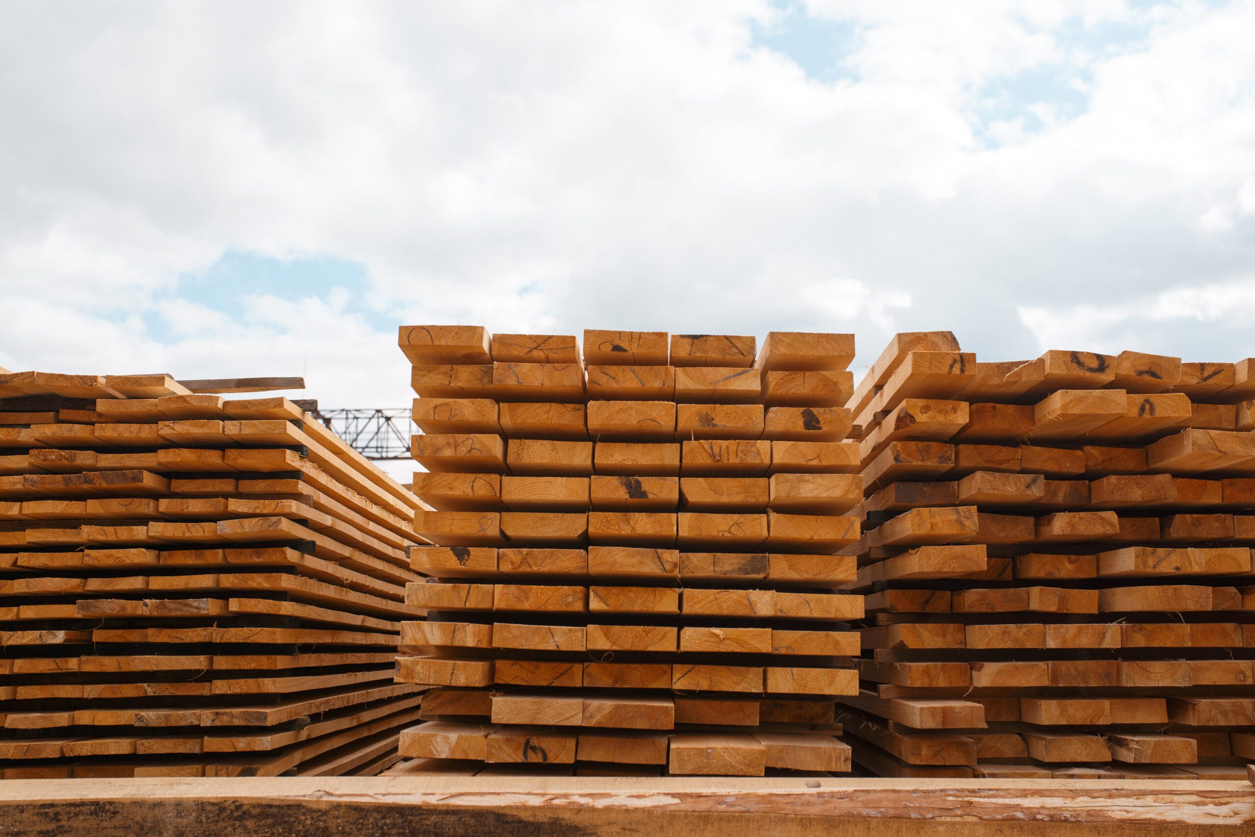 pilhas-de-tabuas-no-armazem-moinho-de-madeira-ao-ar-livre-ninguem-industria-madeireira-carpintaria-processamento-de-madeira-na-fabrica-corte-florestal-em-serraria-serraria-scaled.jpg